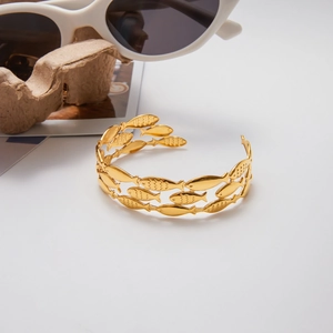 Gold stainless steel open bangle with cutout fish pattern and hammered texture detail