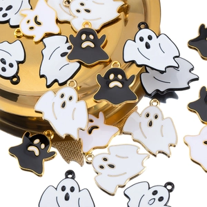 Detailed macro of black and white enamel ghost pendants on a gold decorative tray
