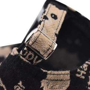 Detail of silver metal adjustment buckle on black and beige jacquard texture baseball cap