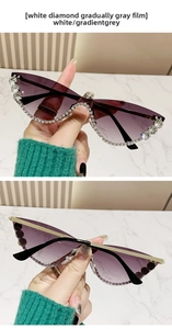 Detail of luxury sunglasses with white diamonds and gradient grey lenses on marble