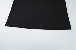Detailed close-up of the black dress hem with high-quality double-needle stitching and fabric