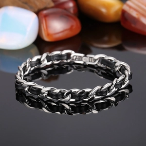 Détail du bracelet en cuir noir tressé avec chaîne NK en acier sur support miroir