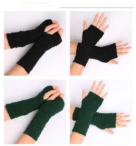 Detail of cable knit arm warmers in dark green and black with thumb hole design