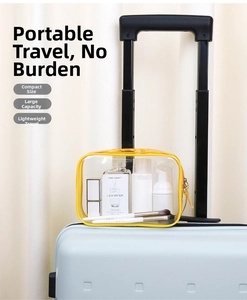Close-up of a yellow transparent PVC waterproof toiletry bag on a blue suitcase