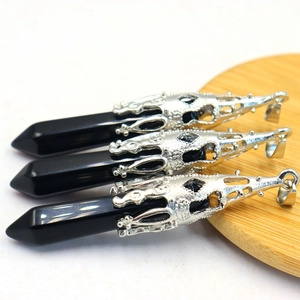 Detailed view of three black hexagonal crystal pendants with silver ornate metal caps