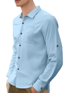Detail of light blue linen shirt featuring a breast pocket and fine fabric texture