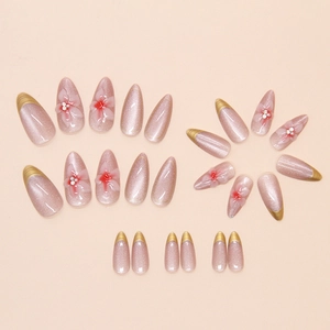 Detail of nude pink press-on nails with 3D floral accents and French almond tips
