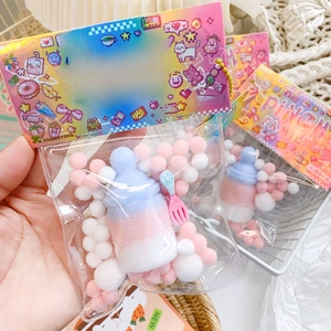 Detailed view of PINCH FAMILY baby bottle squishy toy with colorful plush balls inside