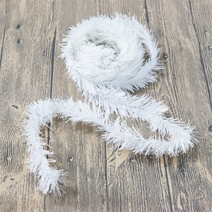White Christmas pine needle garland for festive wall decoration on wooden background
