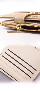 Close-up of leaf metal buckle, gold zipper and card slots on beige leather wallet