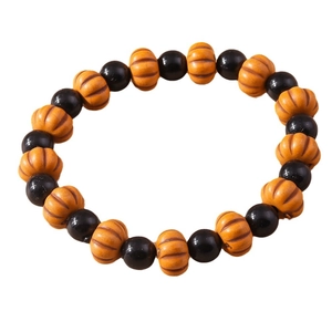 Halloween beaded bracelet featuring black round beads and orange pumpkin charms