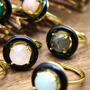 Detailed macro view of faceted crystal stones on golden rings with a rustic wood background
