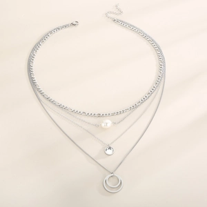 Close-up of layered silver titanium necklace with pearl and zircon round pendants