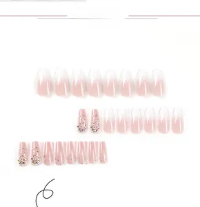 Macro detail of nude pink gradient press-on nails with glitter and handcrafted rhinestones