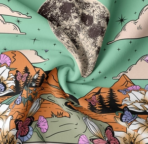 Dettaglio macro dell'arazzo verde menta con stampa di fiori, luna e montagne