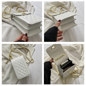 Detail view of white quilted mini crossbody bag with gold chain strap and internal compartments