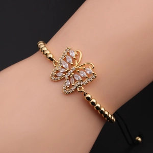 Close-up of golden butterfly bead bracelet with zircons and black adjustable cord on wrist
