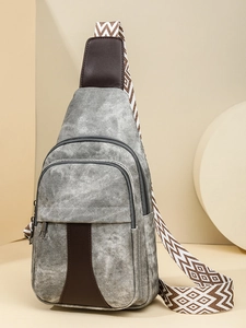 Gray textured crossbody chest bag with decorative brown leather and geometric strap