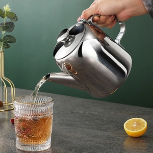 Action shot of pouring tea from a 304 stainless steel kettle into a textured glass cup