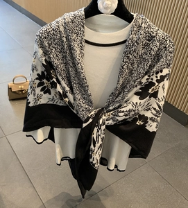 Detail of a black and white cotton-linen printed scarf styled over a white blouse