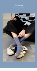 Detailed close-up of blue and brown striped cotton socks paired with white slippers