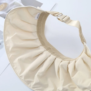 Detail of adjustable metal buckle and woven strap on beige bow sun hat with branding