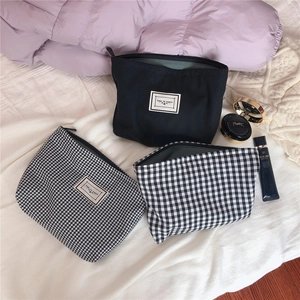 Detailed view of chic black and checkered cotton cosmetic bags with Time To Party labels