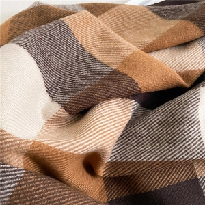 Close-up of thick plaid scarf texture showing warm brown and beige woven fibers