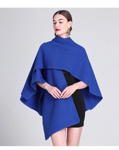 Detail of royal blue wool poncho showing thick knit texture and asymmetric layered design