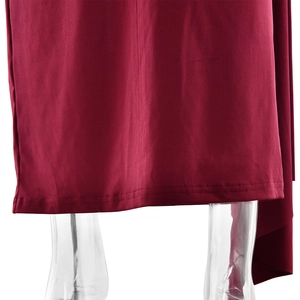 Gros plan détaillé de l'ourlet de la robe rouge foncé montrant le tissu et les coutures