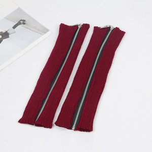 Detail view of burgundy knitted leg warmers with full-length silver metal zippers