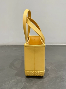 Detailed side view of yellow waterproof EVA beach tote bag with perforated texture