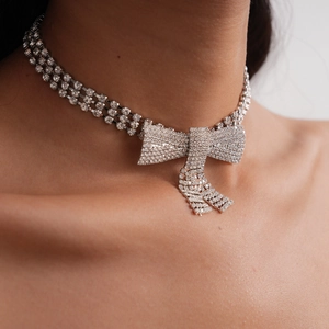 Close-up of luxury rhinestone bow choker with sparkling tassels on model neck