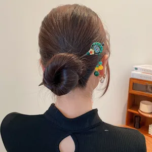 Détail d'un pic à cheveux chinois vintage avec glands sur un chignon élégant