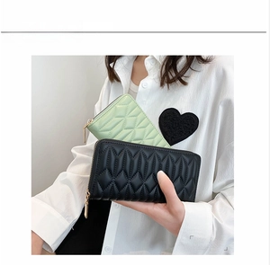 Detail of quilted PU leather women's long wallet with secure zipper and tassel pendant