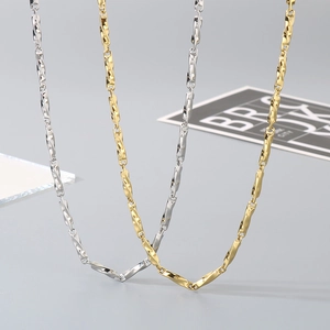 Macro shot of minimalist twisted barrel link necklaces in gold and silver stainless steel