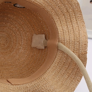 Detail of children straw hat interior featuring sweatband and chin strap sewing