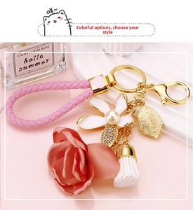 Close-up of floral keychain with pink leather rope, pearl flower and silk rose