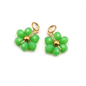 Close-up of handmade green beaded flower pendants with gold metallic wire loop connectors