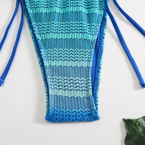Dettaglio dello slip bikini testurizzato blu e verde con lacci laterali regolabili