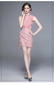 Détail de la robe rose sans manches en mesh avec broderie florale et ourlet plissé