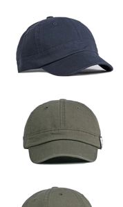 Detail of short brim cotton baseball caps in navy and olive with retro wash texture