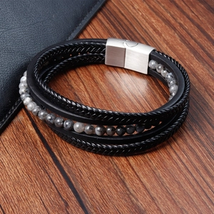 Close-up of double-layer men's braided leather bracelet with gray stone beads and magnetic clasp