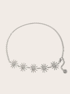Détail de pendentifs soleil argentés sur une chaîne de taille en métal pour femme avec fermoir