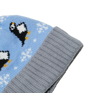 Detail of light blue knit beanie with penguin jacquard pattern and ribbed grey cuff