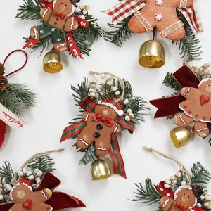 Handmade gingerbread man Christmas hanging ornament with bells, pine needles and bows