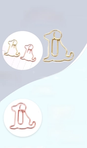 Macro detail of dog-shaped carbon steel paperclips in gold and rose gold plating