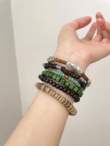 Nahaufnahme von Bohemian-Mehrlagenarmbändern aus Holz und Türkis am Handgelenk