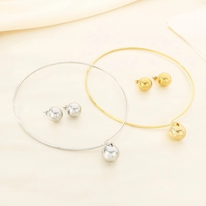 Detailed view of hollow sphere necklace and earrings set in gold and silver finish