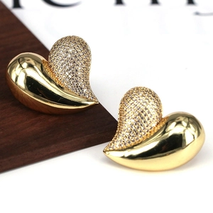Detail of gold heart stud earring with half polished metal and half pavé cubic zirconia